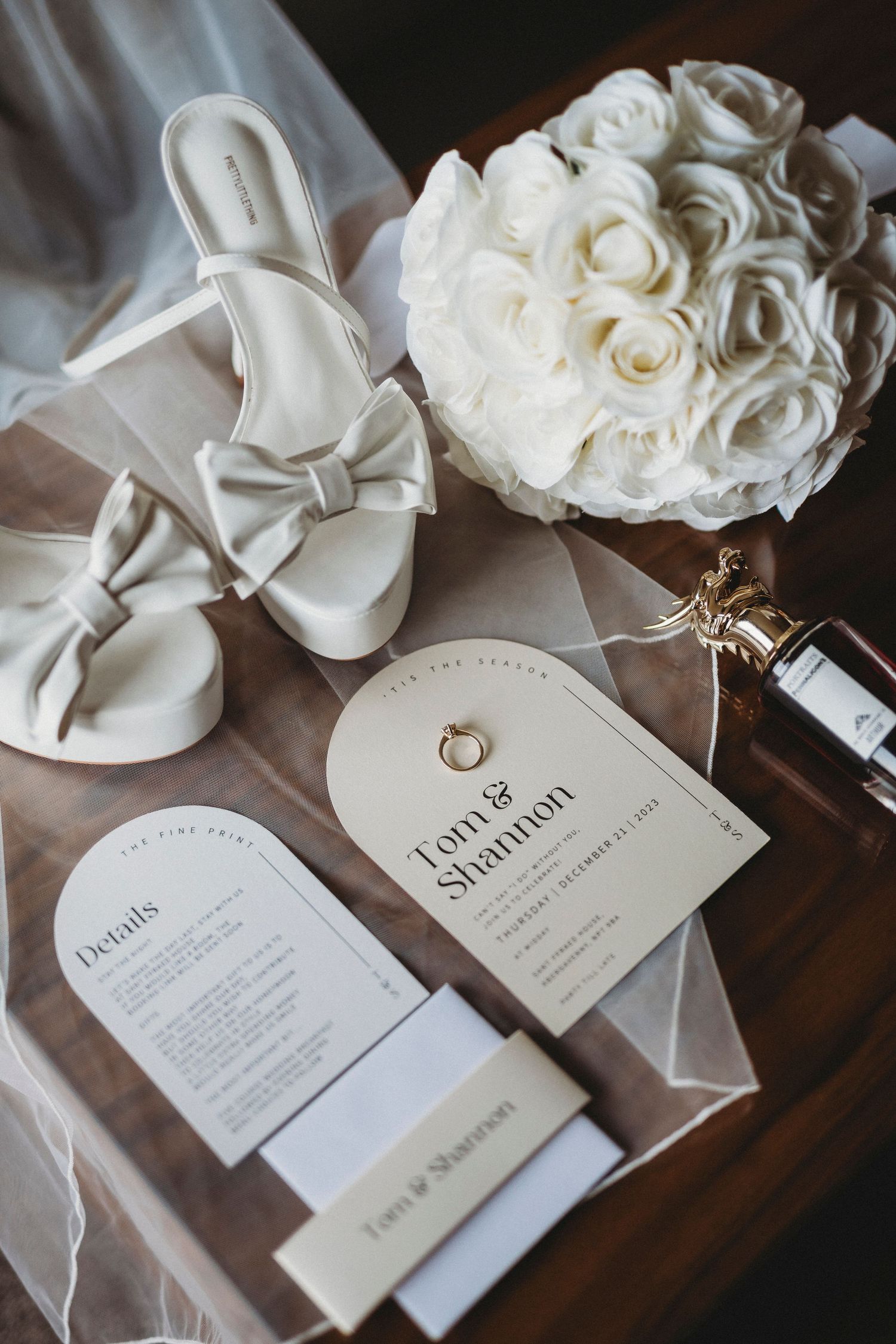 Elegant white wedding invitations with roses and delicate ribbon details.