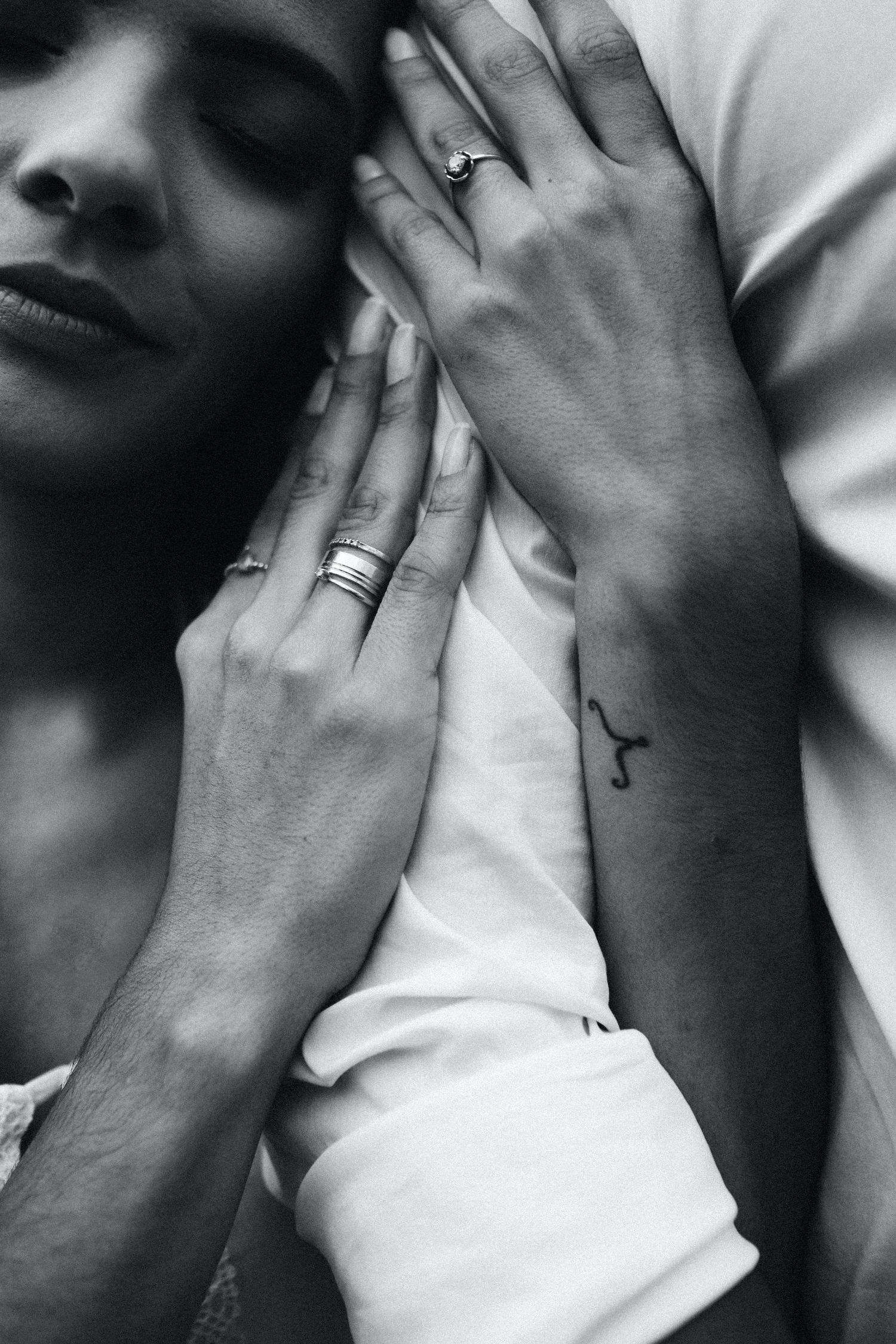 Woman hugging her man's arm showing engagement ring