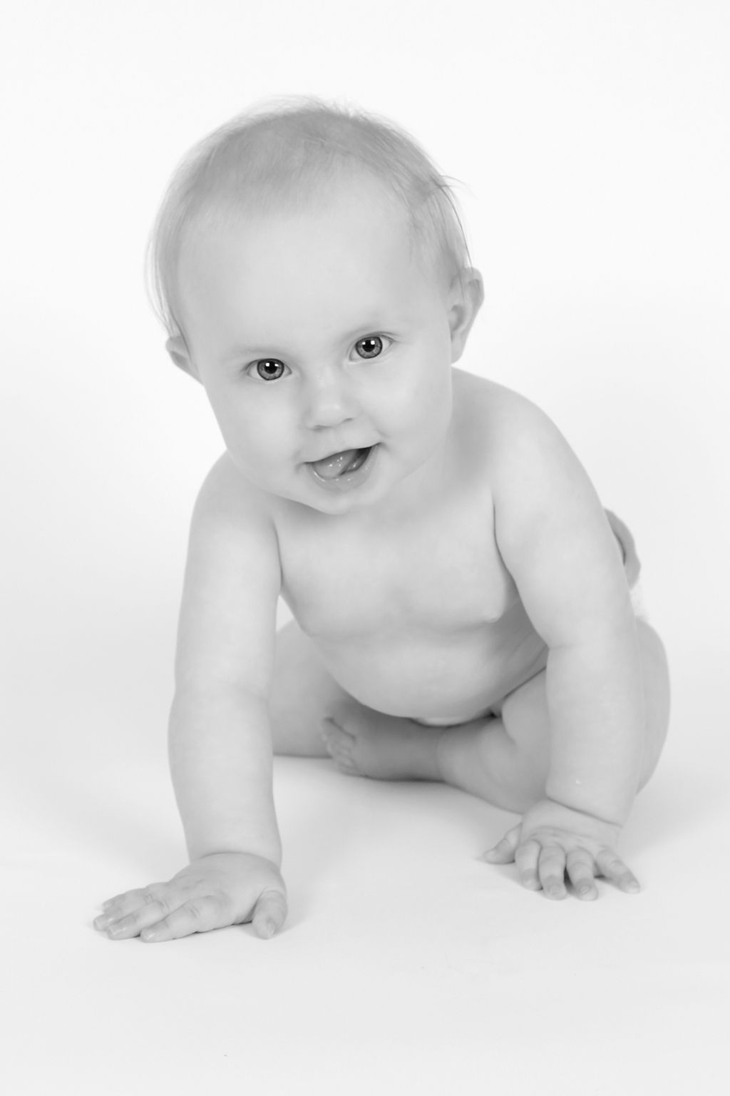 Black and white photo of crawling baby against white background.