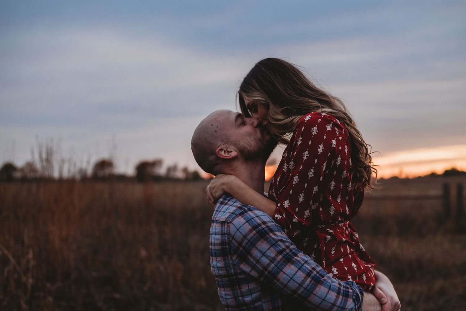 one year anniversary couple kiss during golden hour