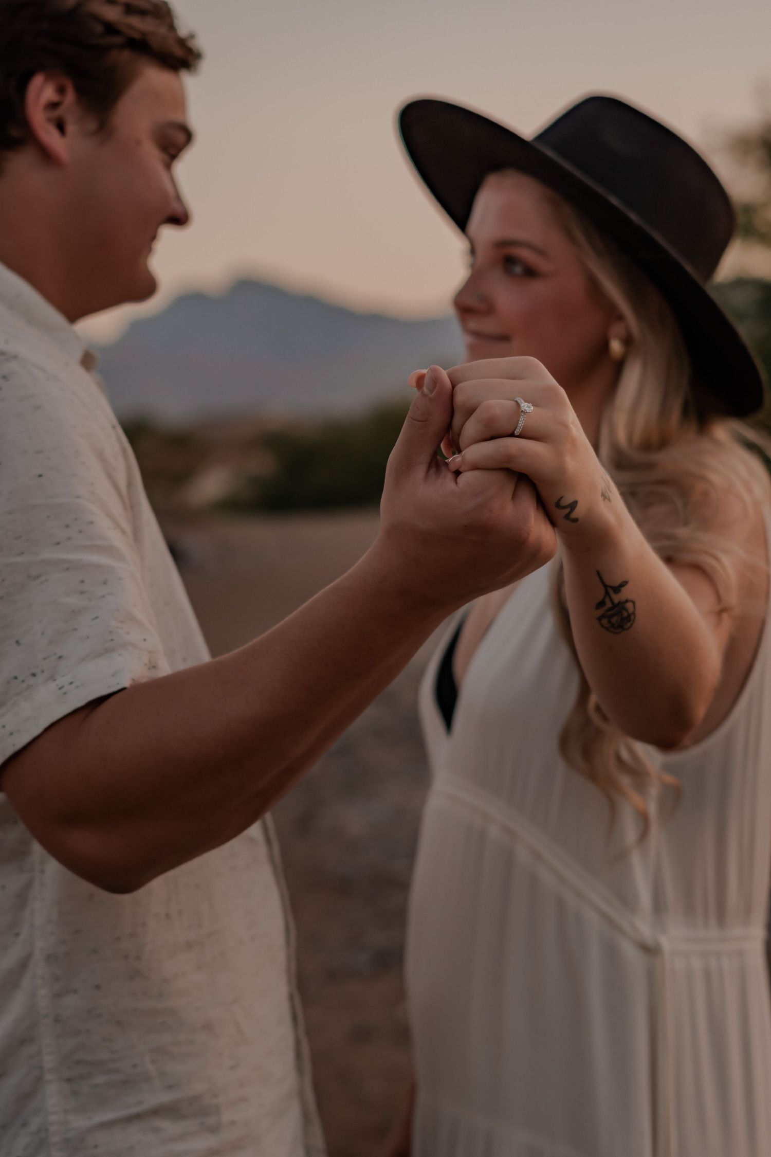 sunset photo of engagement ring detail shot showing couple
