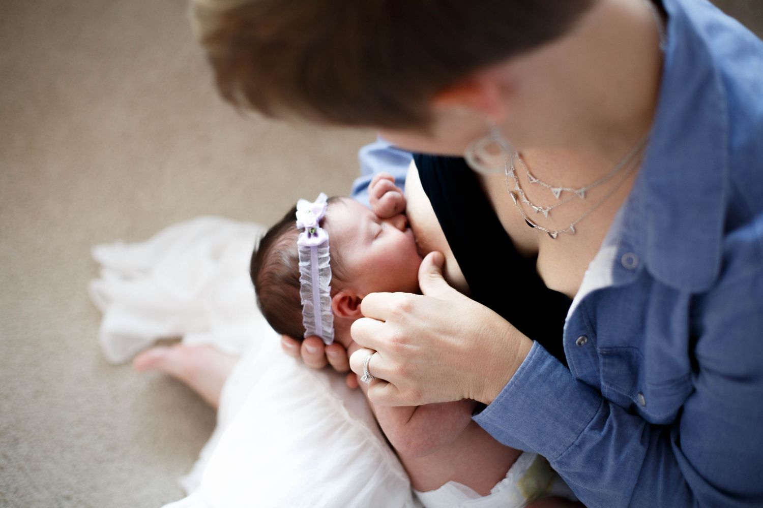 Everett newborn photography: a mother breastfeeds her newborn baby girl at an in-home lifestyle newborn session
