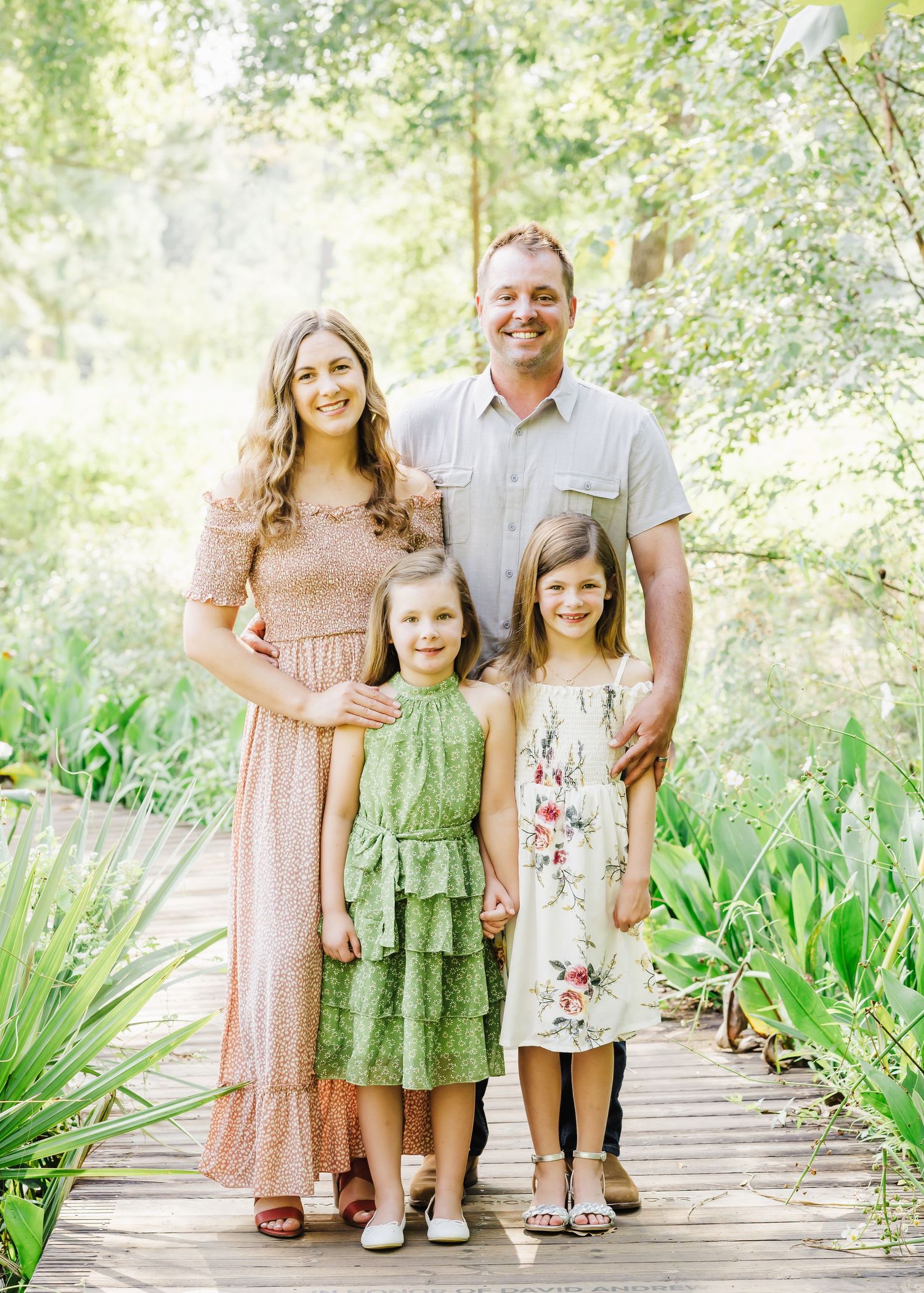Family of four taking fall family portraits at the Houston Arboretum in the morning
