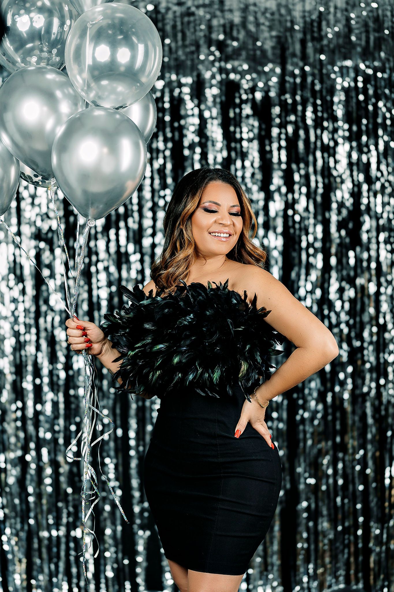 Glamorous party scene with silver balloons against sparkly backdrop.