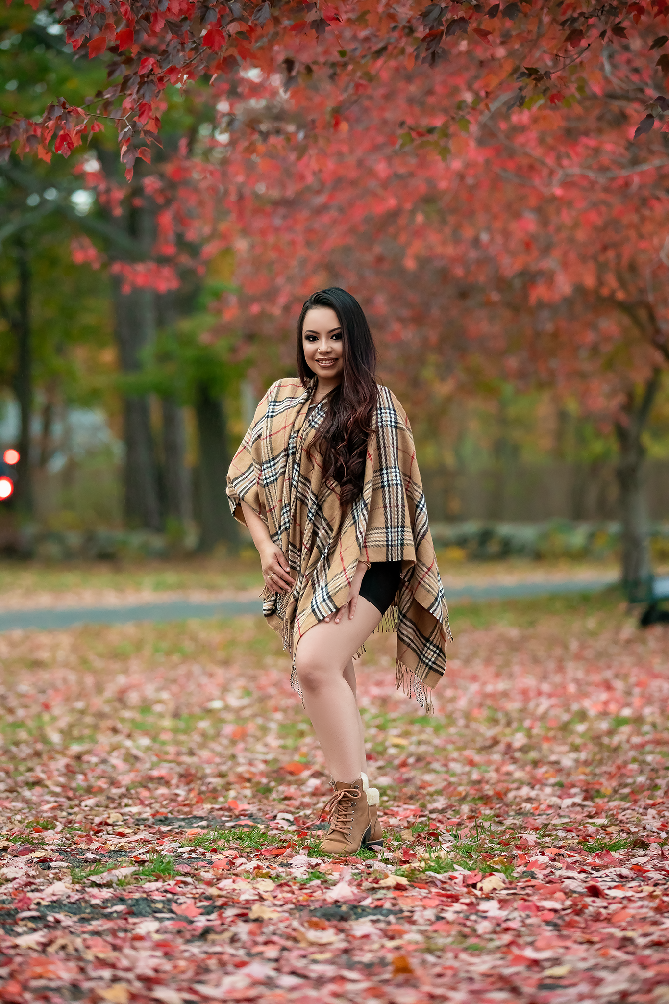 Fall photoshoot with autumnal red maple leaves scattered on the ground.
