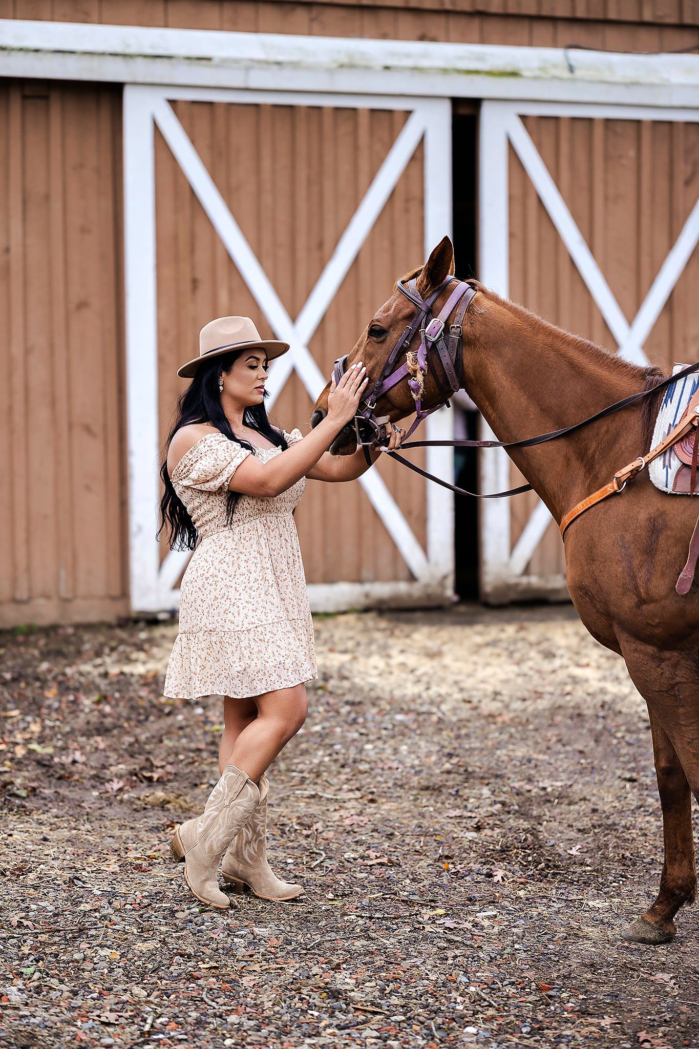 Equestrian themed photoshoot outside wooden barn with casual country styling.
