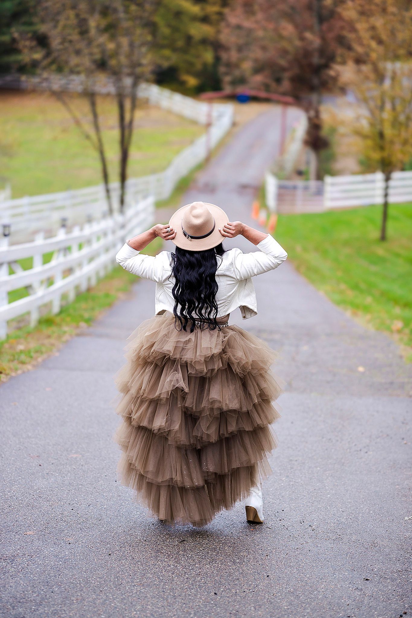 Dancing sequence in brown tulle dress on country road with dramatic spinning movements.