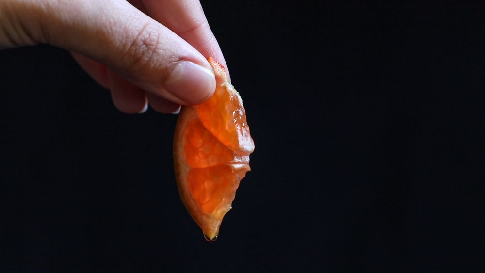 Orangenscheibe wird gehalten