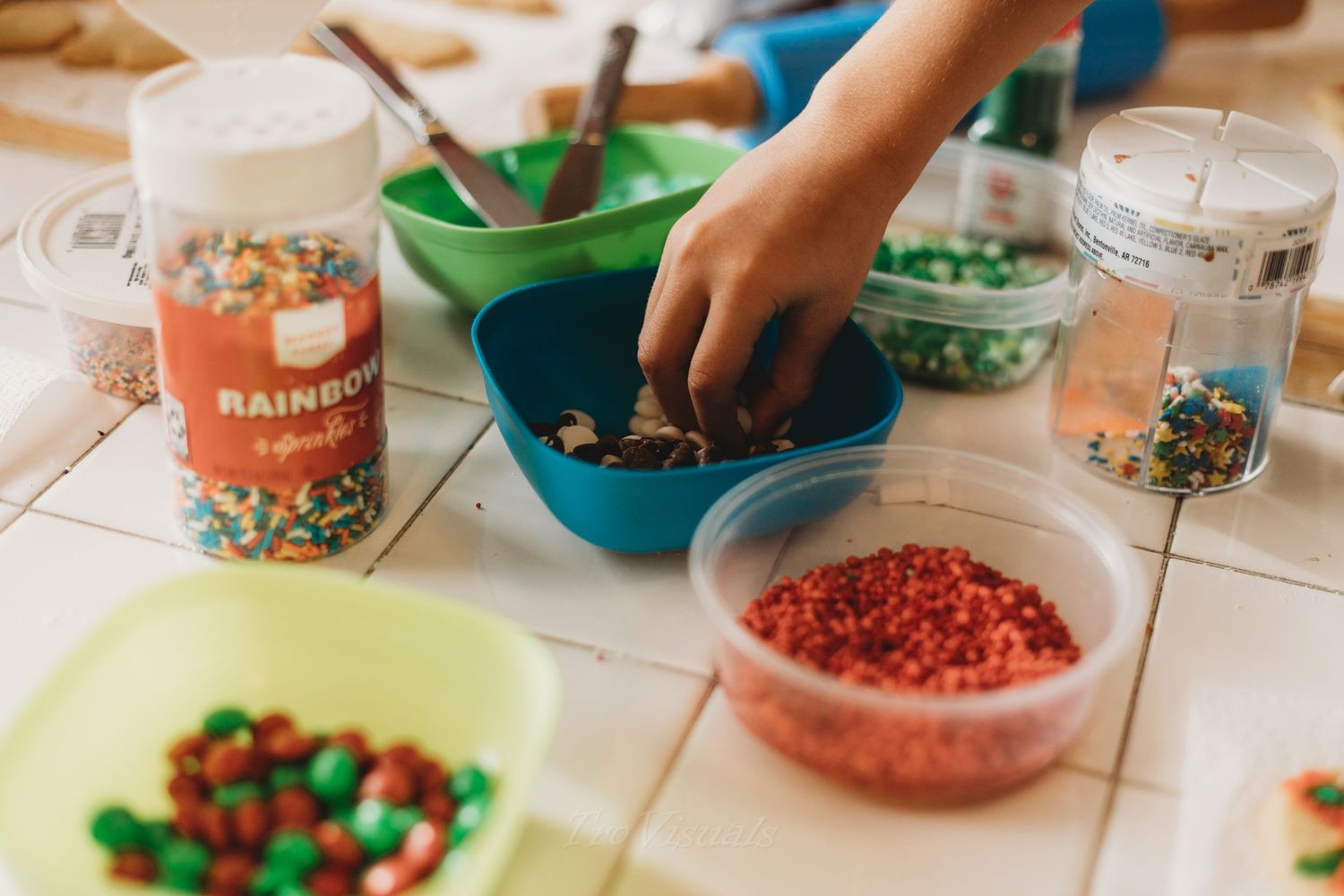 Colorful bowls filled with various ingredients laid out on a wooden table for a cooking activity.