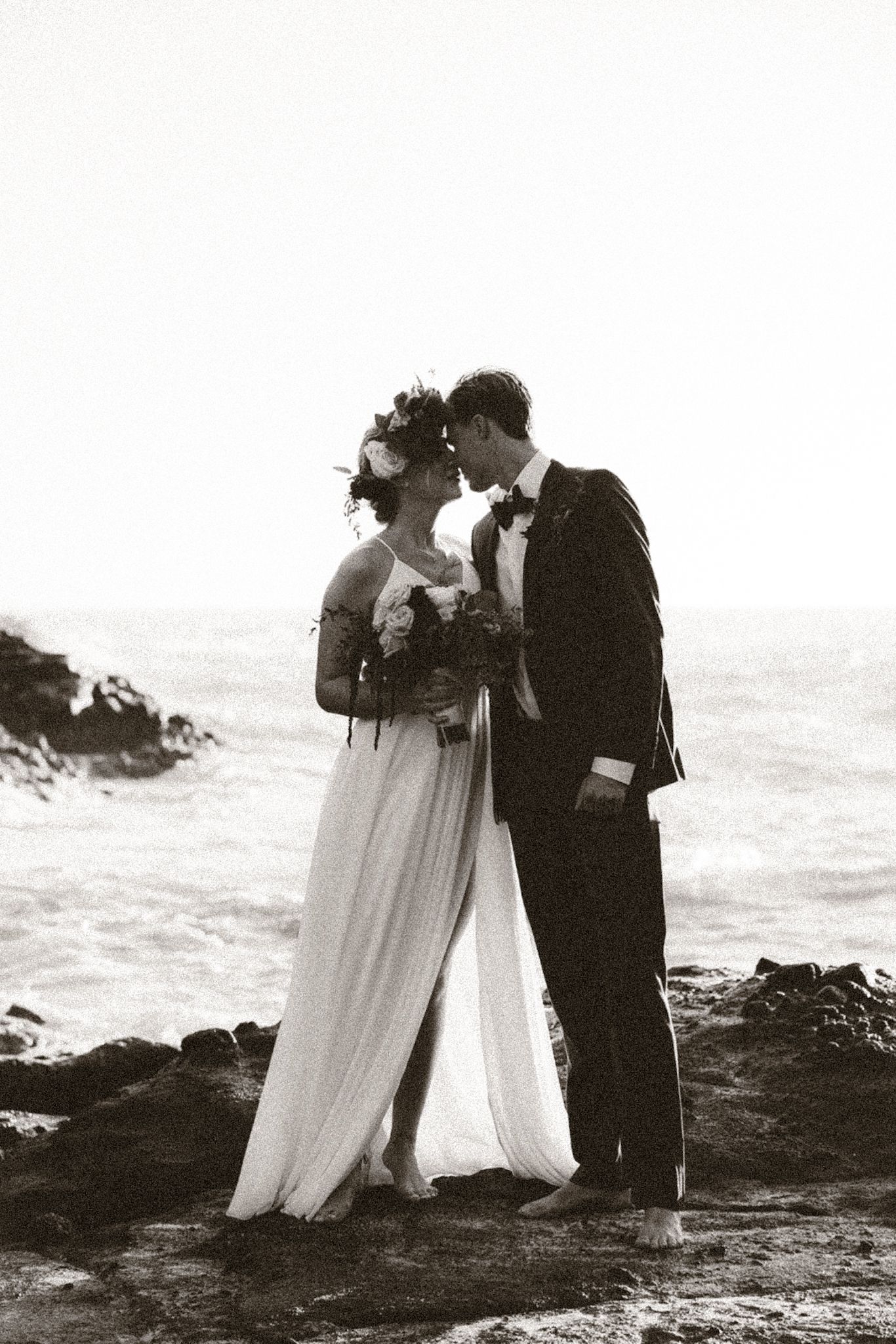Happy couple embraces during intimate elopement against the stunning backdrop of Hawaii's natural beauty