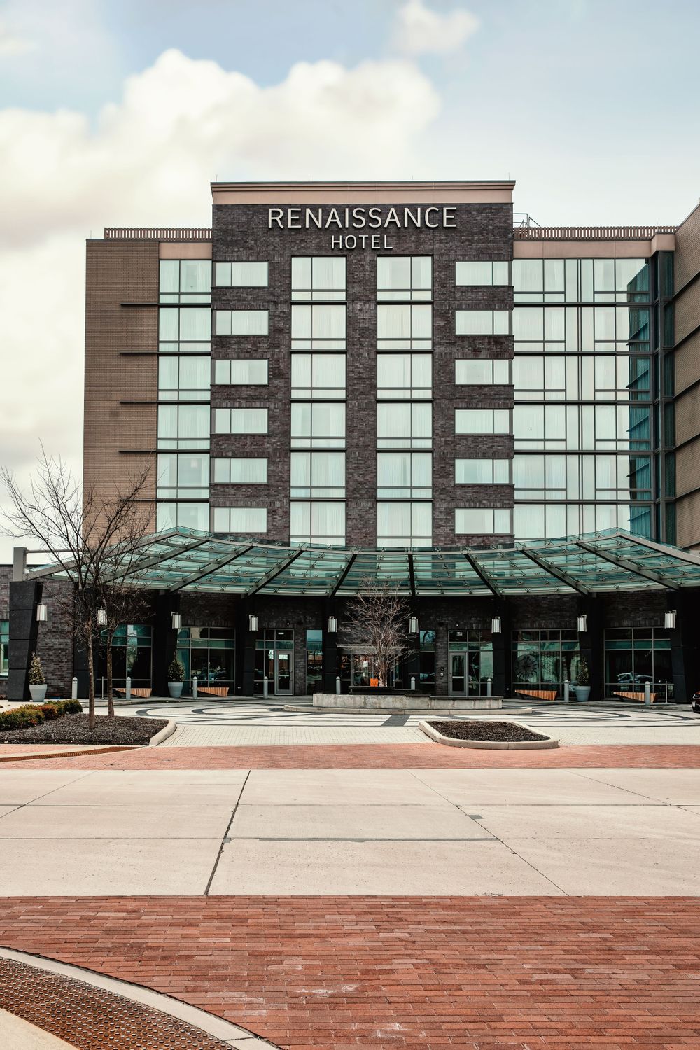 Modern Renaissance Hotel exterior facade with glass windows and brick plaza.