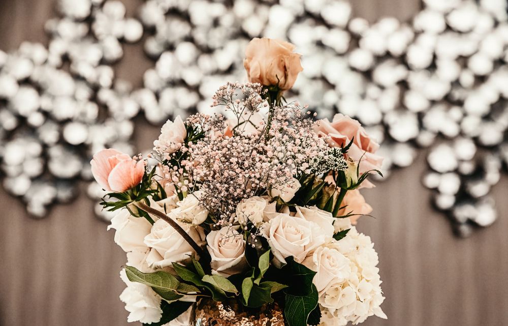 Wedding reception decor featuring delicate pink roses and white floral arrangements.
