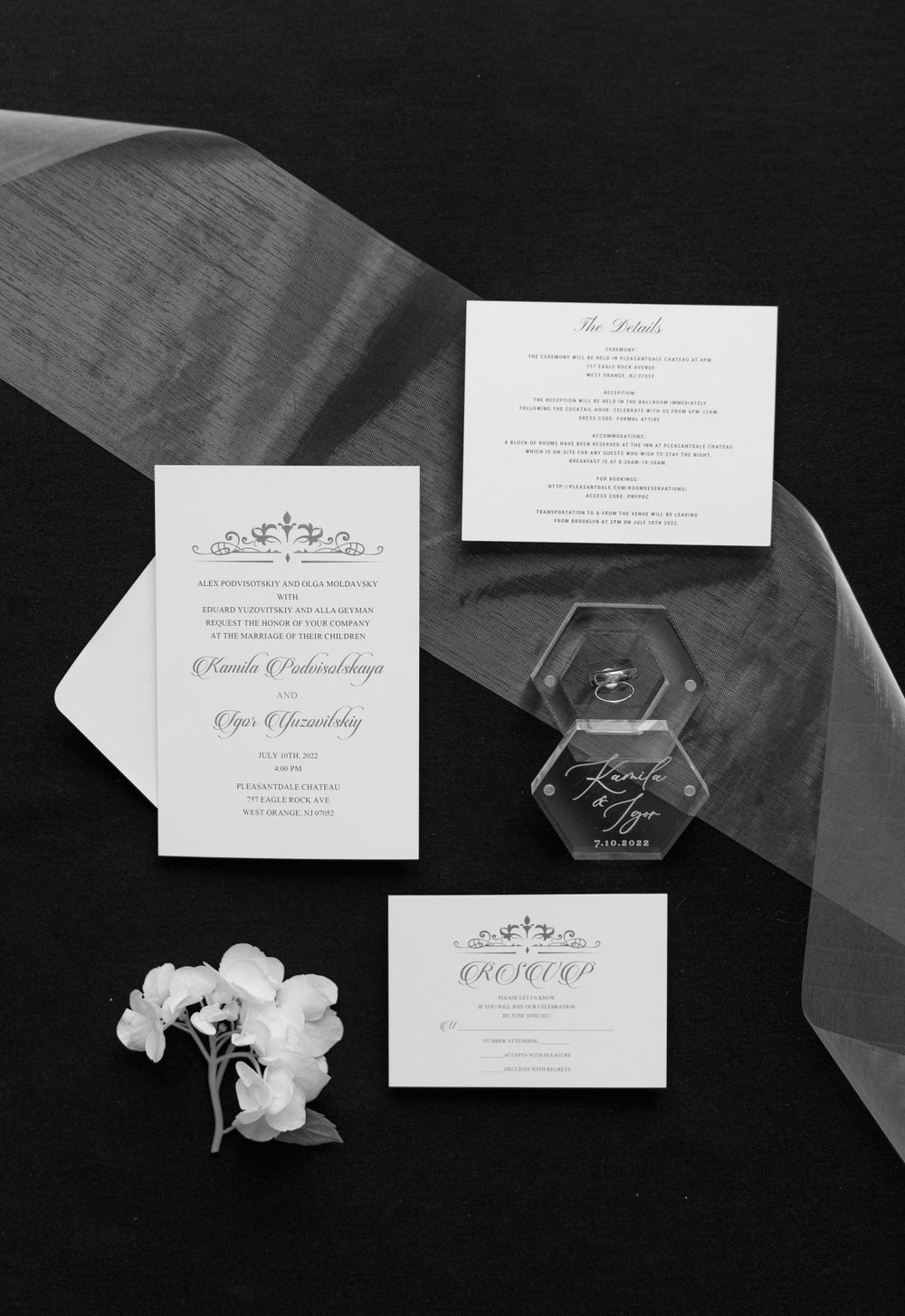 Elegant wedding invitation suite featuring white stationery with floral motifs and silk ribbon.