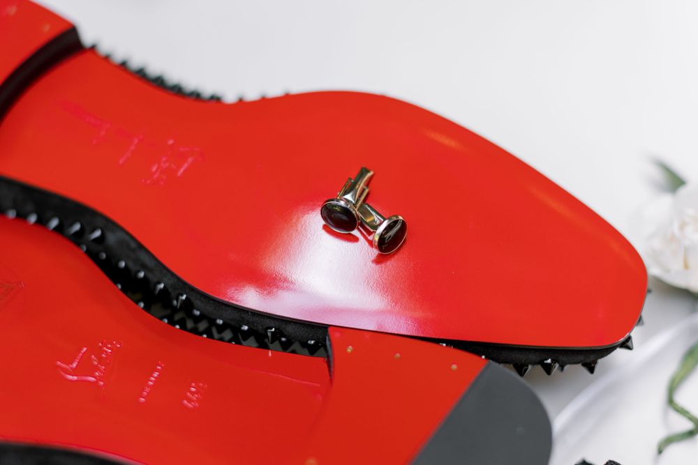 Close-up of red Christian Louboutin shoe sole with signature screw detail.