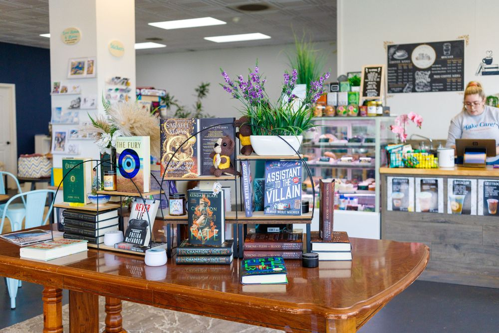 Cozy bookstore interior with wooden tables, shelves of books, and decorative plants.