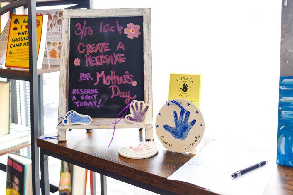 Chalkboard menu and decorative items on wooden shelf in cafe setting.