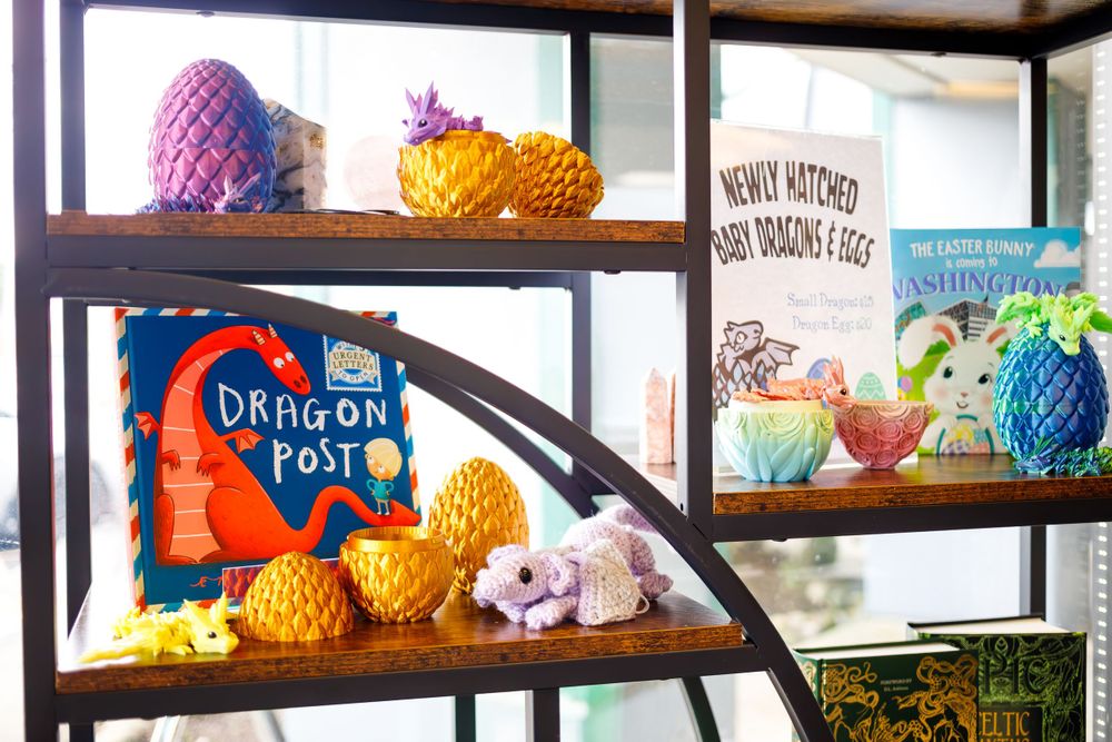 Colorful display shelf with Dragon Post merchandise and decorative pineapples.