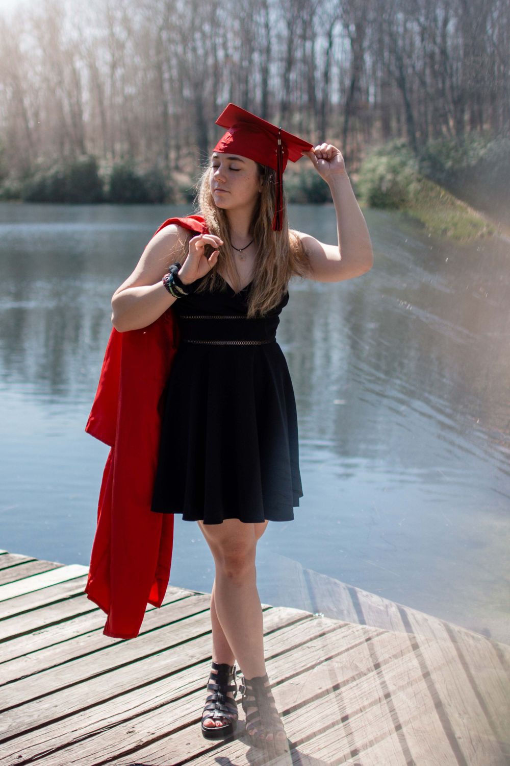 Artistic photo sequence on a wooden dock with a red jacket and black dress by a lake.
