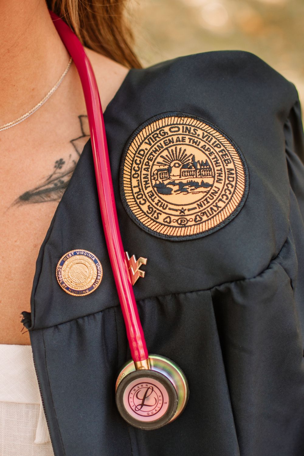 Close-up of university seal and stethoscope on graduation gown showing medical school achievement.