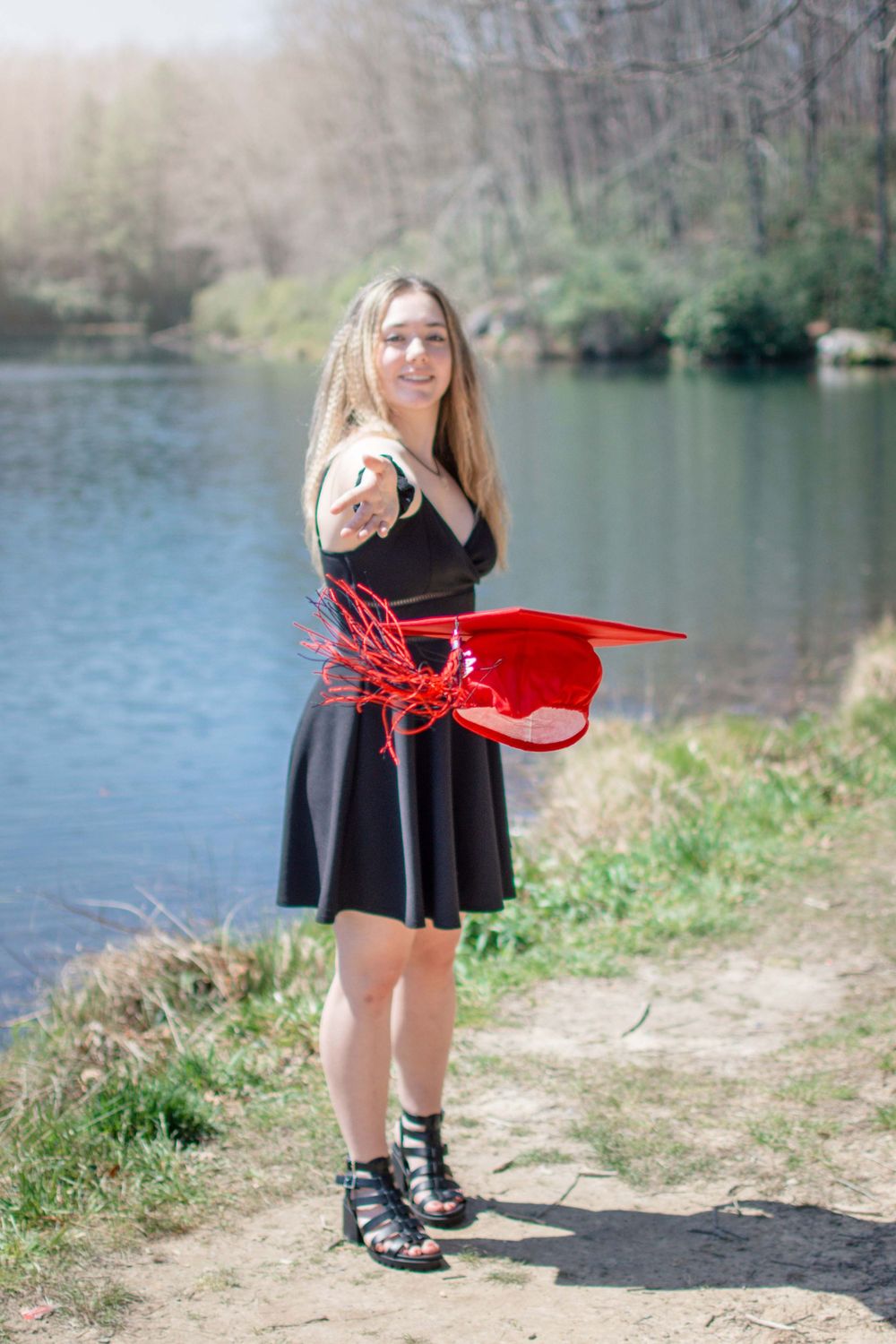 A sequence of photos by a lake showing a black dress and red graduation cap.