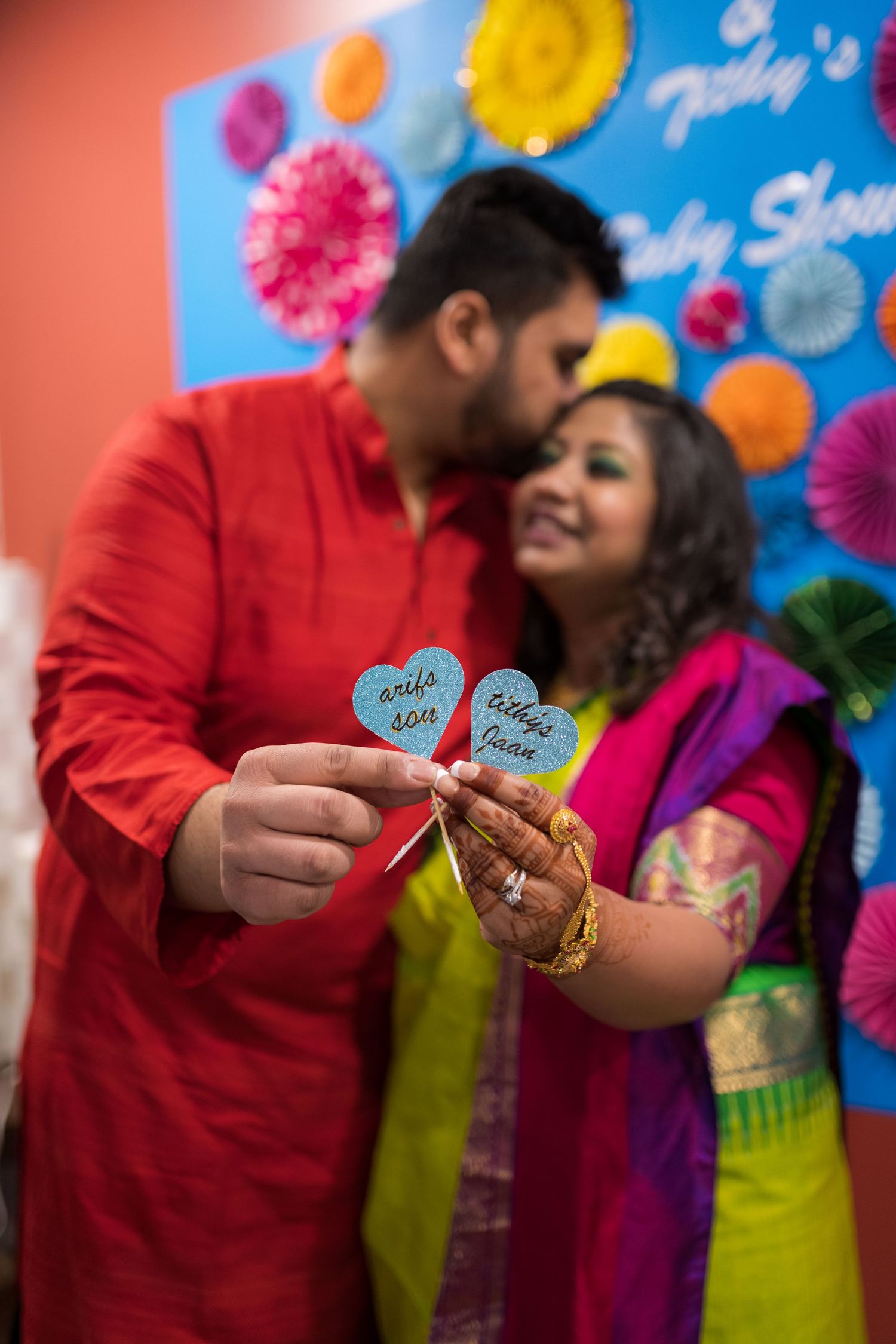 Close-up of hands holding heart-shaped cards at colorful party celebration.