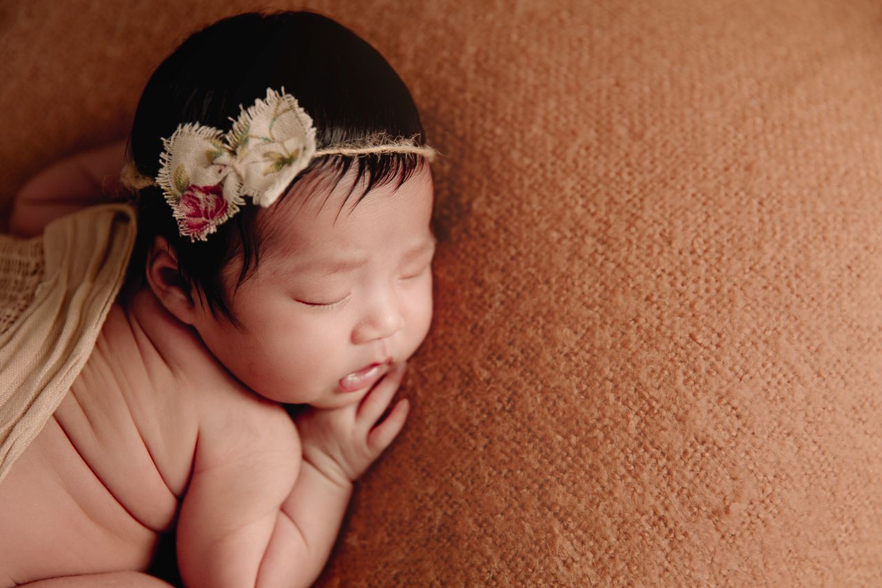 close up profile shot of baby girl on brown blanket with rustic headband
