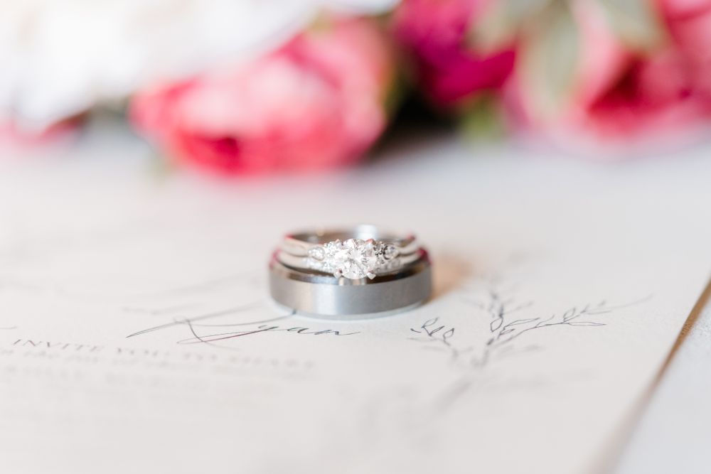 Wedding bands with diamond engagement ring displayed on handwritten paper.