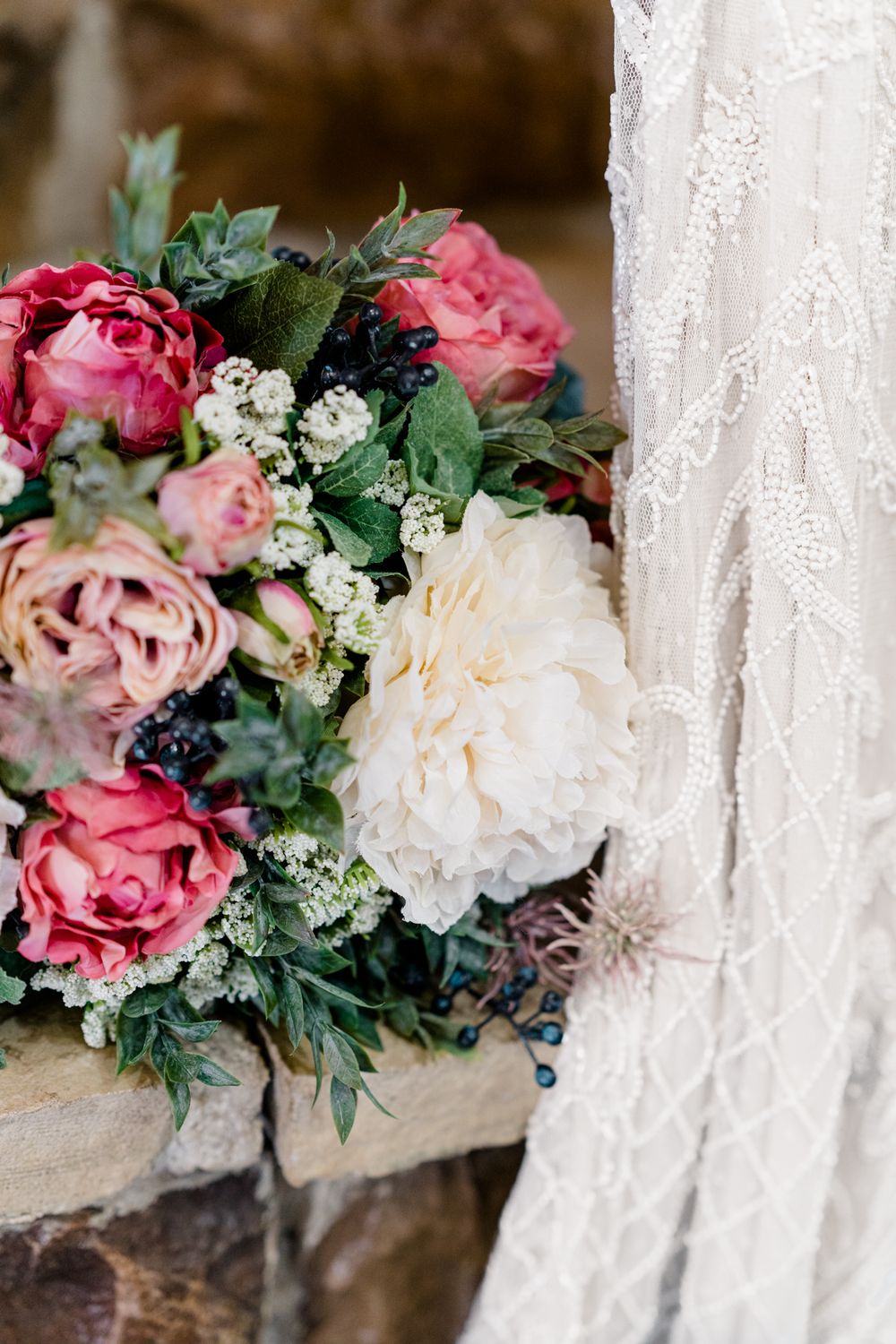 A stunning bridal bouquet with pink and white roses against intricate lace fabric.