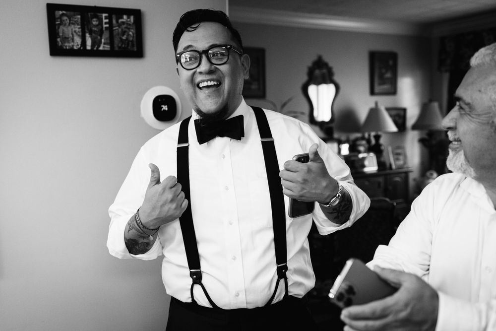 The successful groom gives thumbs up after learning to tie his real bow tie on the morning of his wedding.