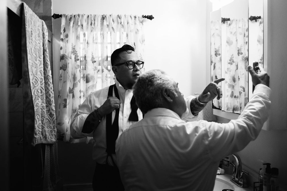 Father and son watch Youtube videos to figure out how to tie a real bowtie on the wedding day.