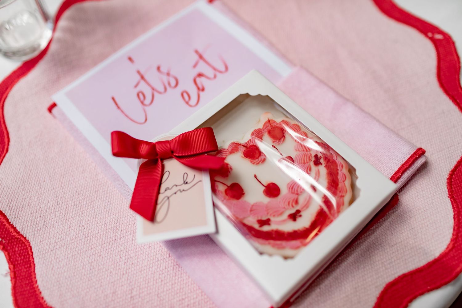 Close-up of a pink and red Valentine's-themed card with a decorative bow.