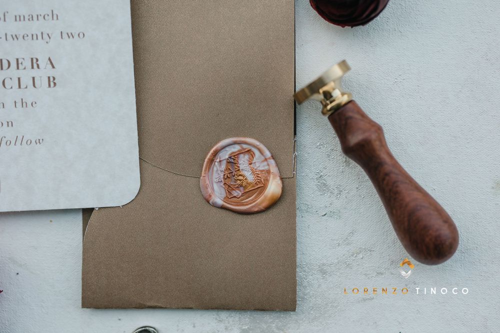 Close-up of wax seal and wooden stamp on elegant wedding stationery.