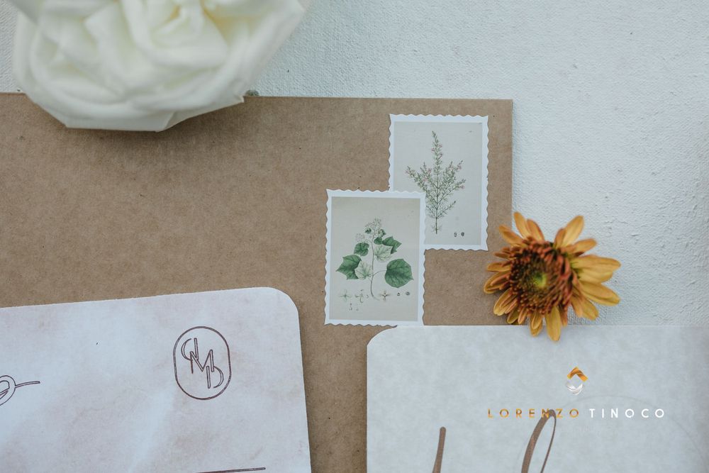 Detail shot of vintage postage stamps and sunflower on wedding stationery corner.