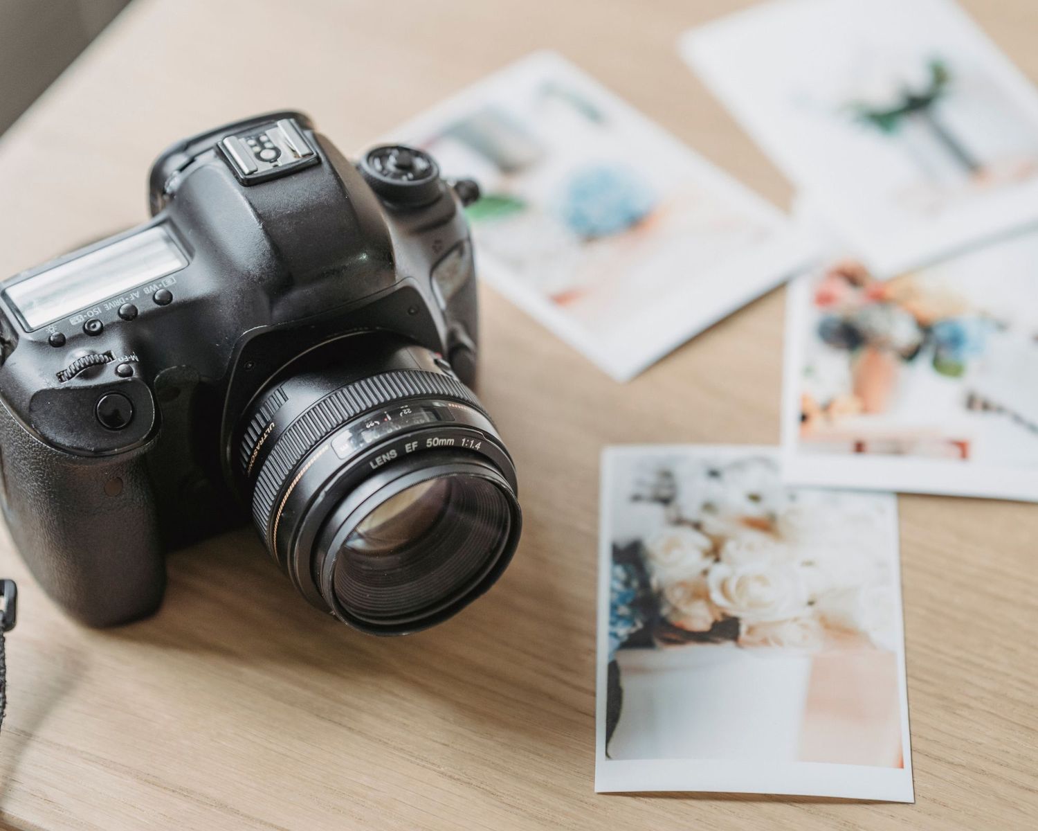 DSLR camera next to printed photos