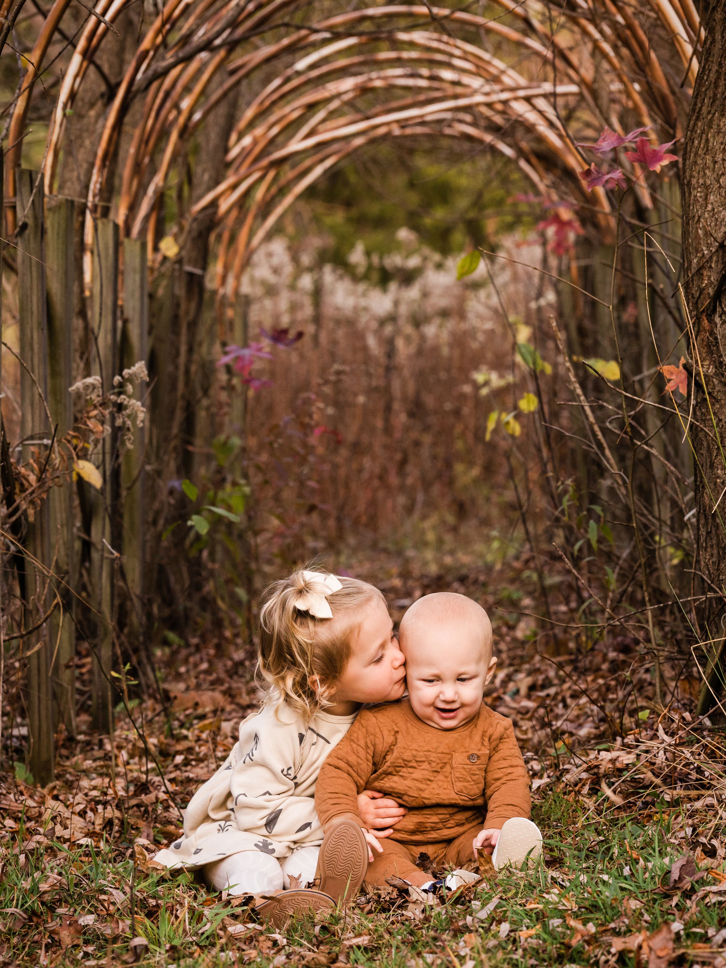 Fall family photography of sister whispering to little brother