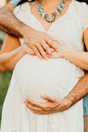 Husband & wife embrace their new baby to come in Houston.