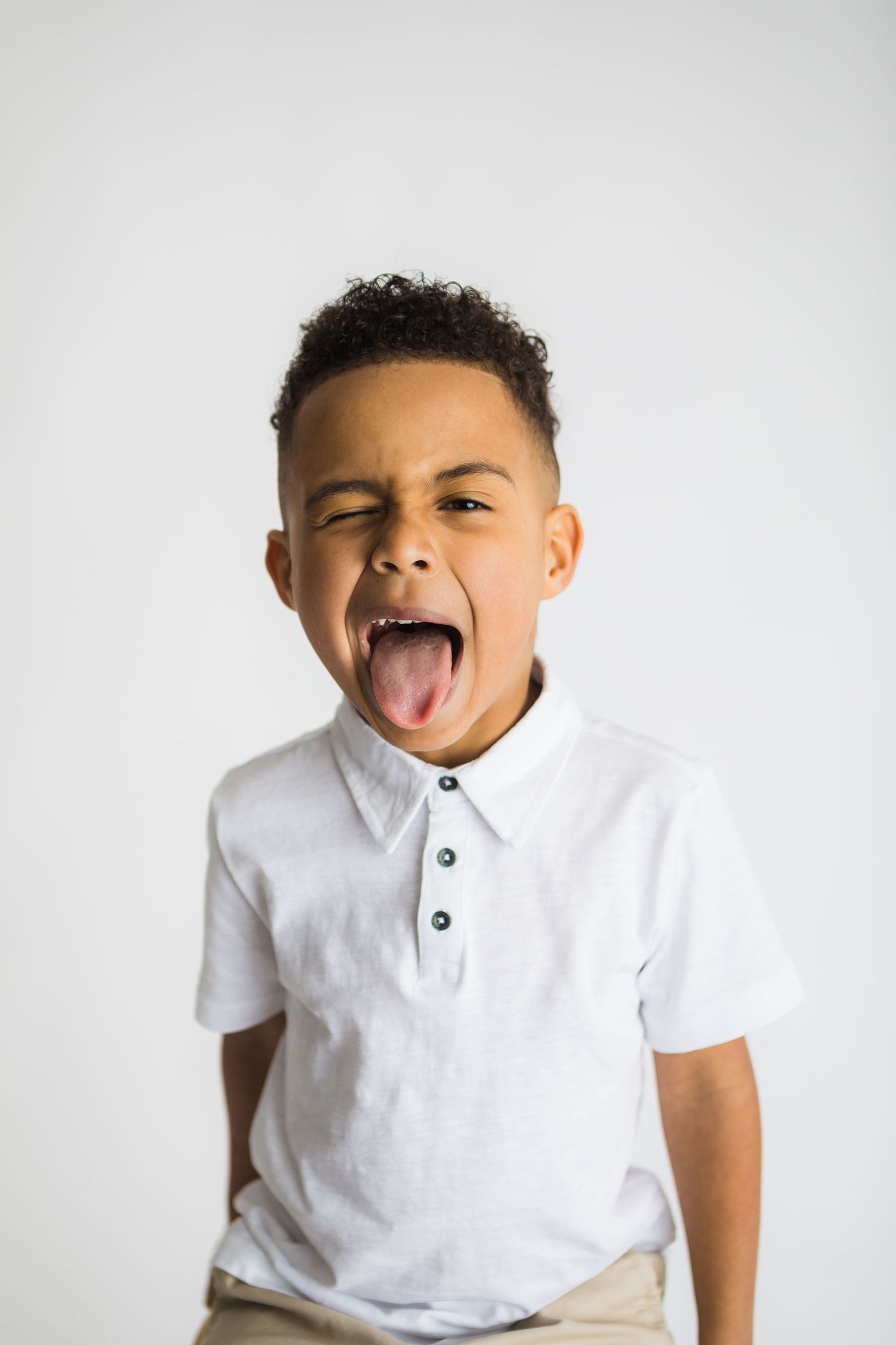 Studio portrait series showing different playful expressions against white background.