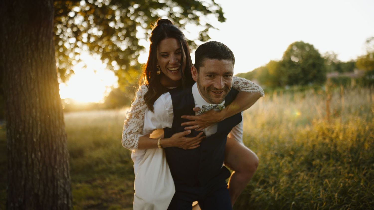 Mariée sur le dos de son homme au couché de soleil
