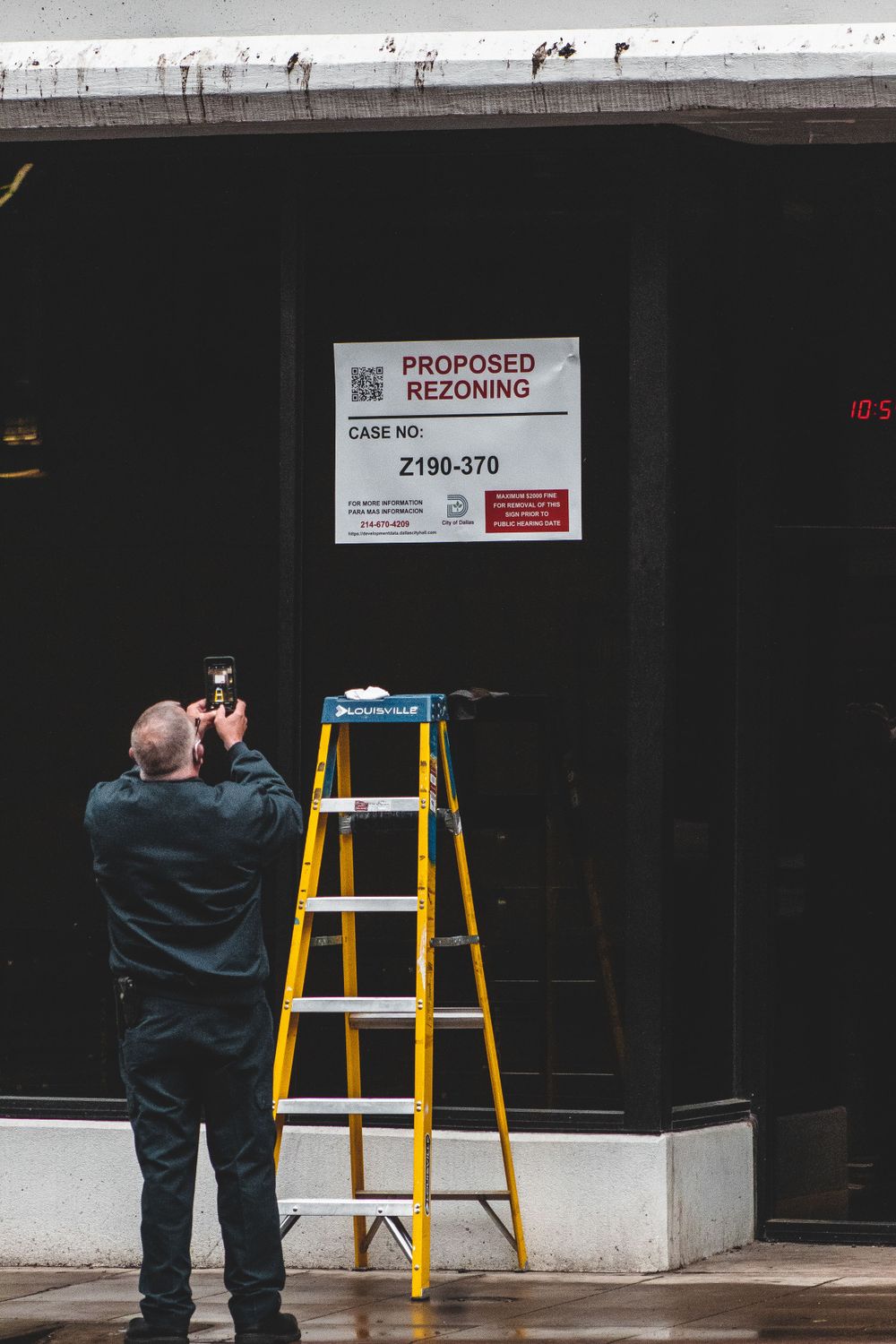 Man Taking Picture of Sign in Dallas, Texas