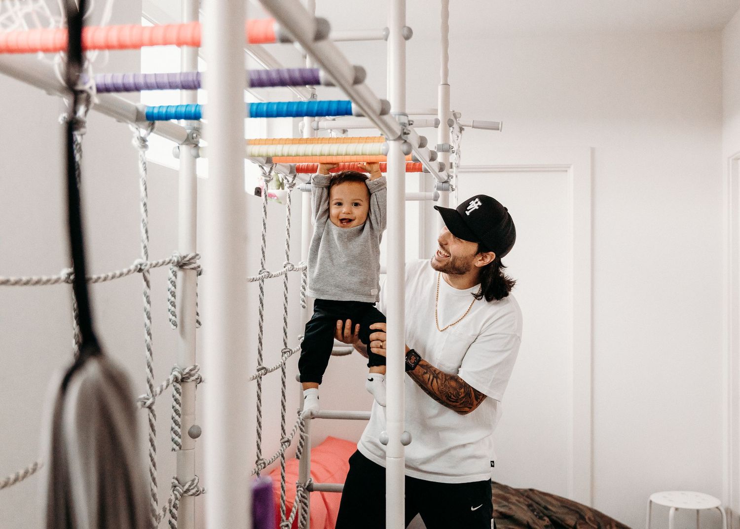 Indoor playtime on monkey bars in a home gym area.