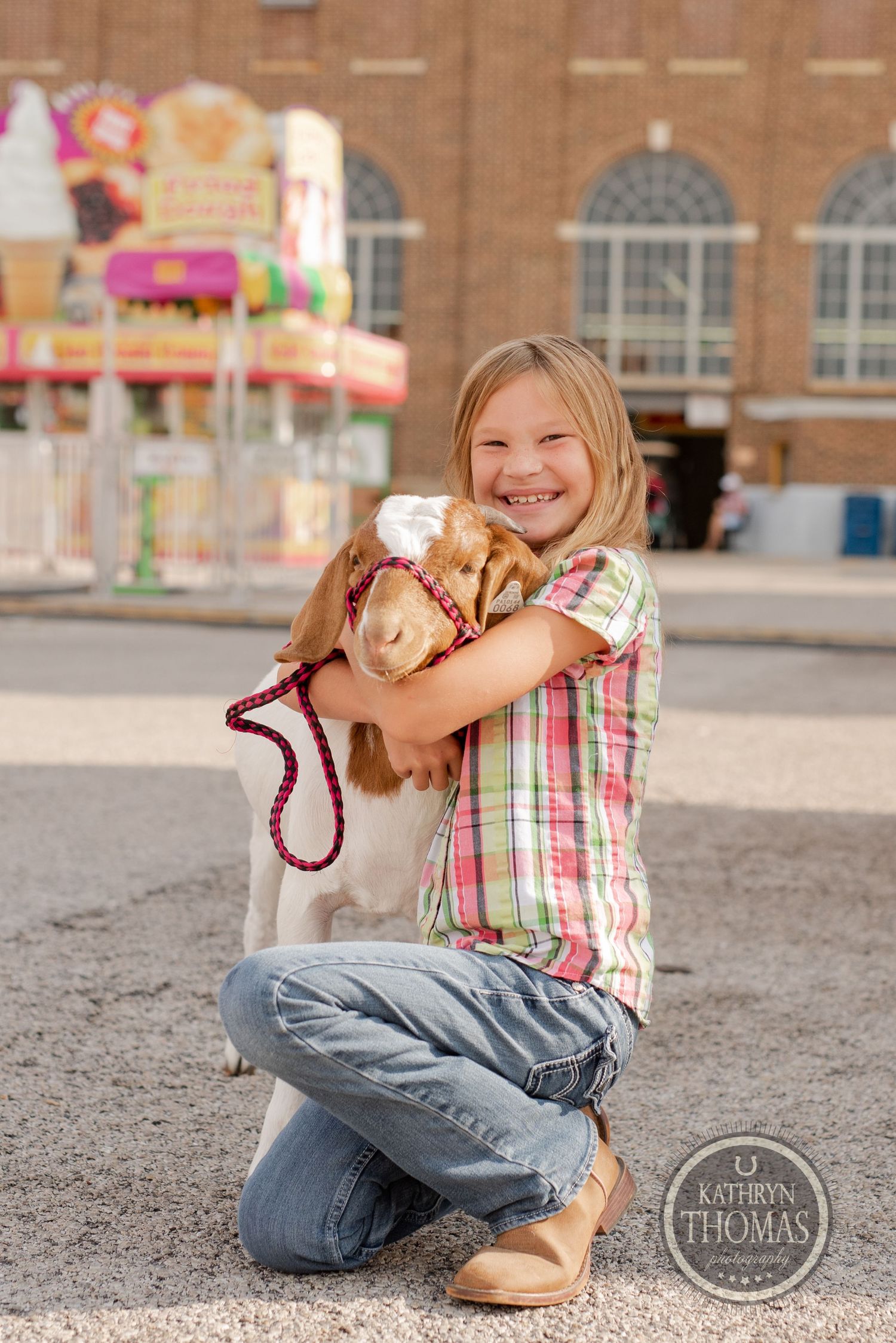 A young exhibitor hugs a small animal at the York Fair.