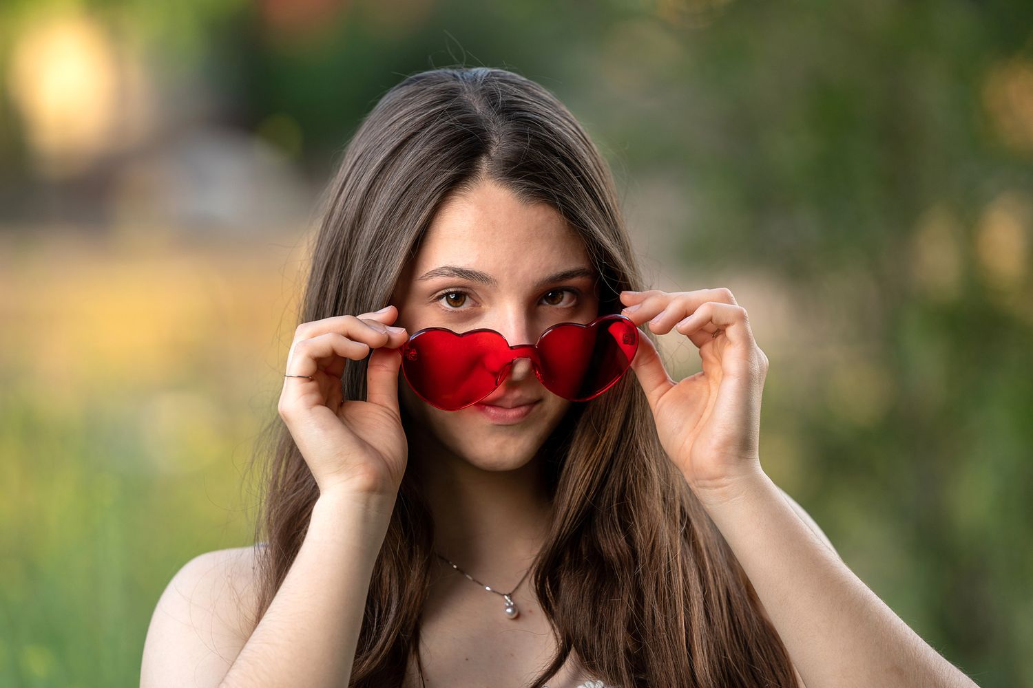 girl-posing-with-rose-colored-glasses-for-graduation-photo