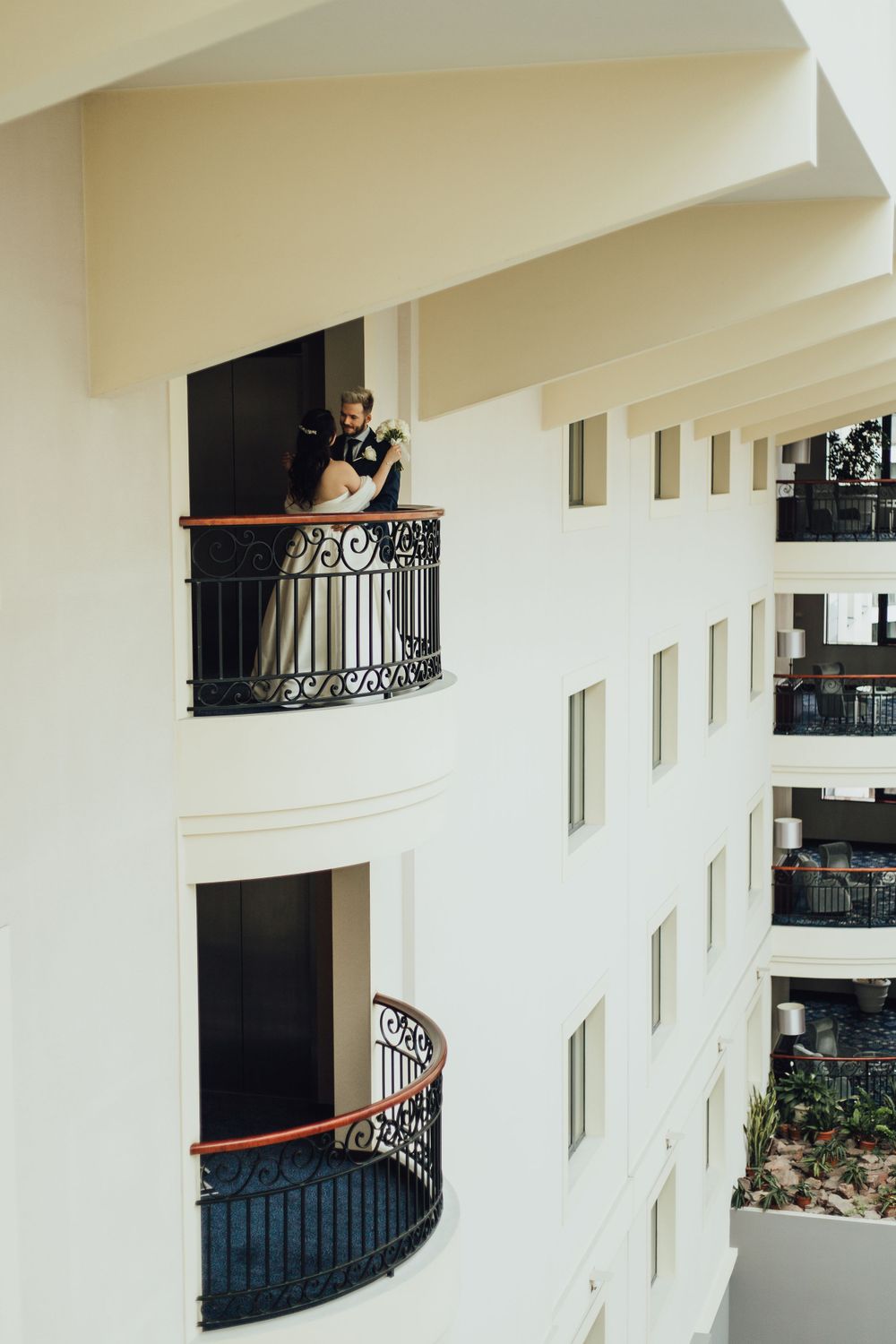 Elegant architecture featuring curved balconies with wrought iron railings inside a modern white building.