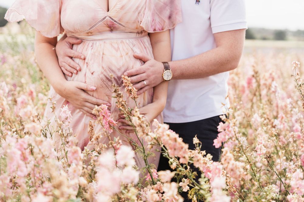 photograph of baby bump being held by father