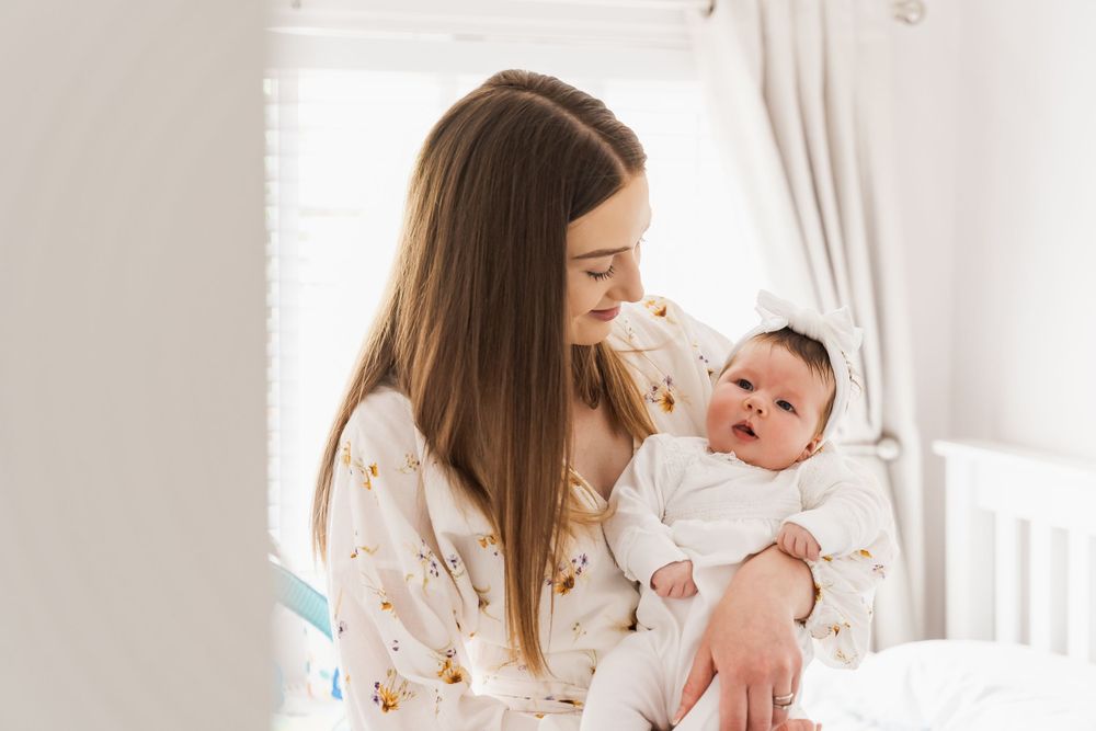 photograph of newborn girl being held by mother in nursery