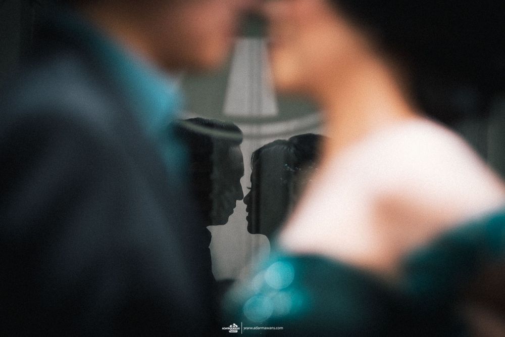 Artistic silhouette reflection creating symmetrical portrait in soft focus.