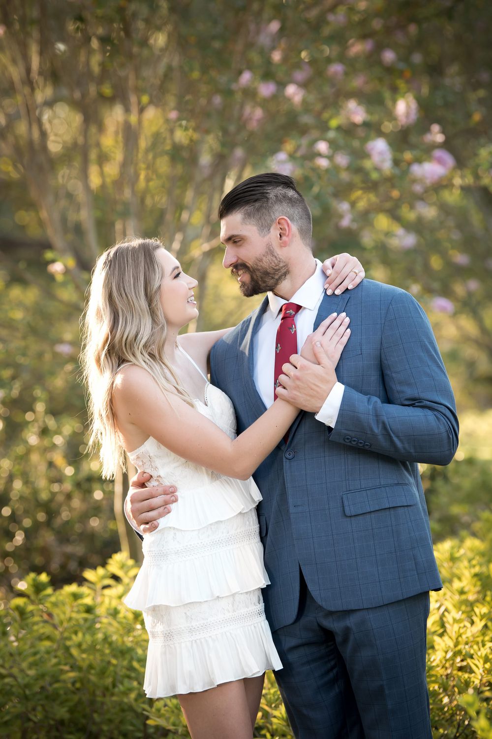 Romantic engagement session in a garden setting with golden hour lighting.