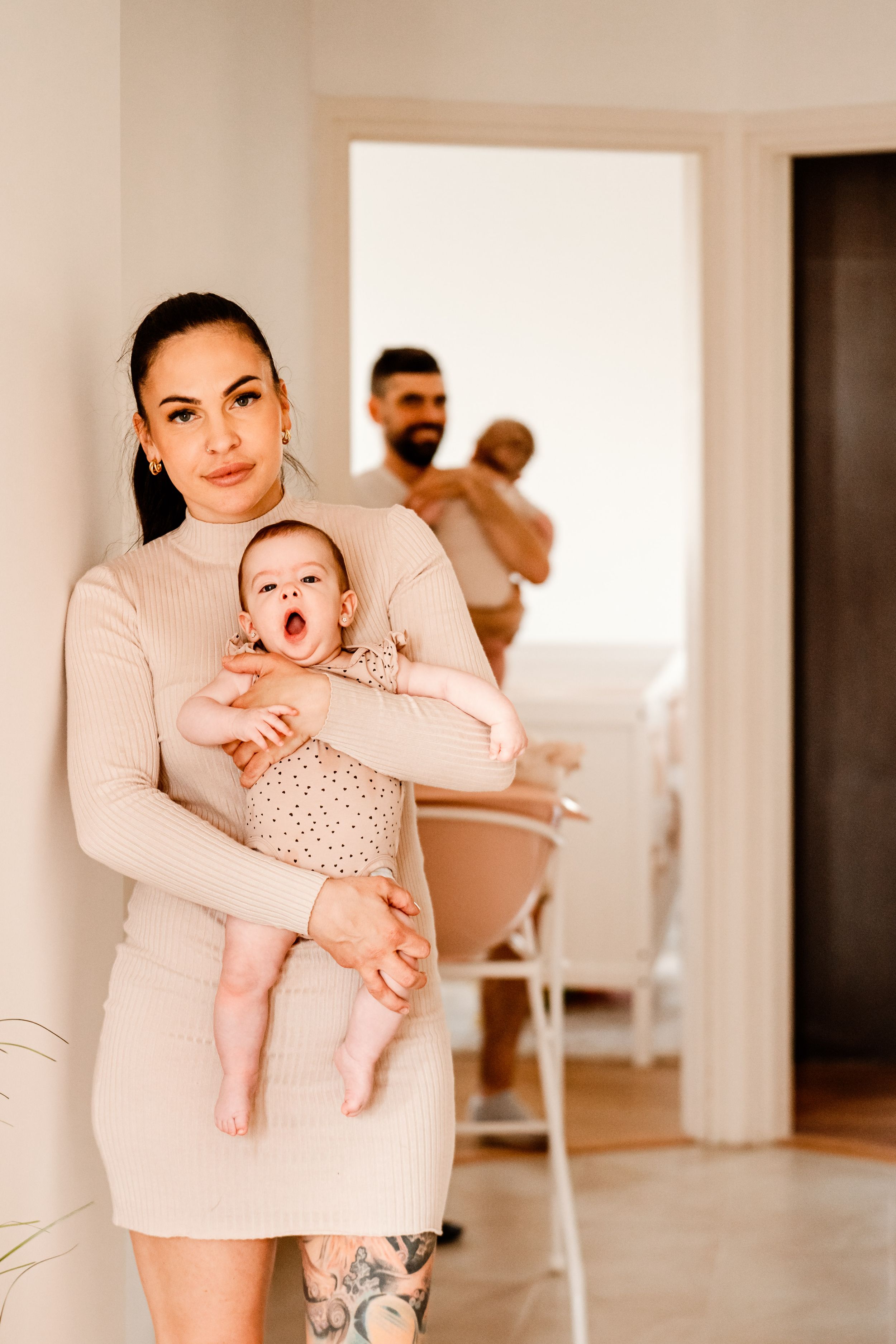 Family moment in neutral-toned room with baby and parents.