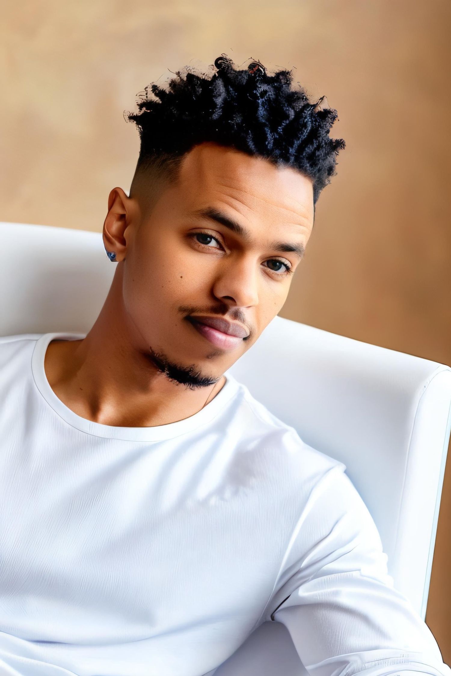 Portrait of person wearing white sweater against warm beige backdrop.