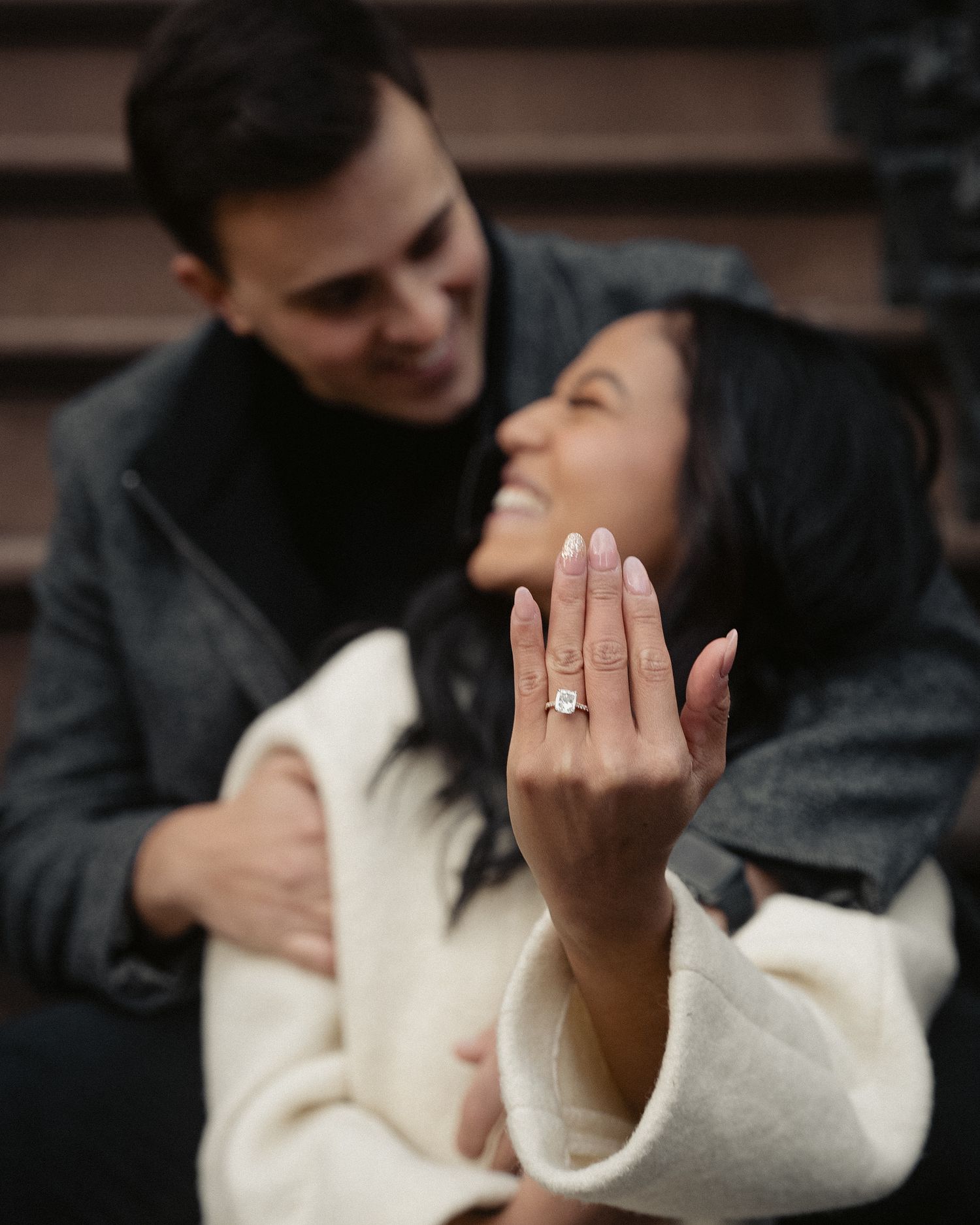 A couple shares a tender moment while showing off a new engagement ring.